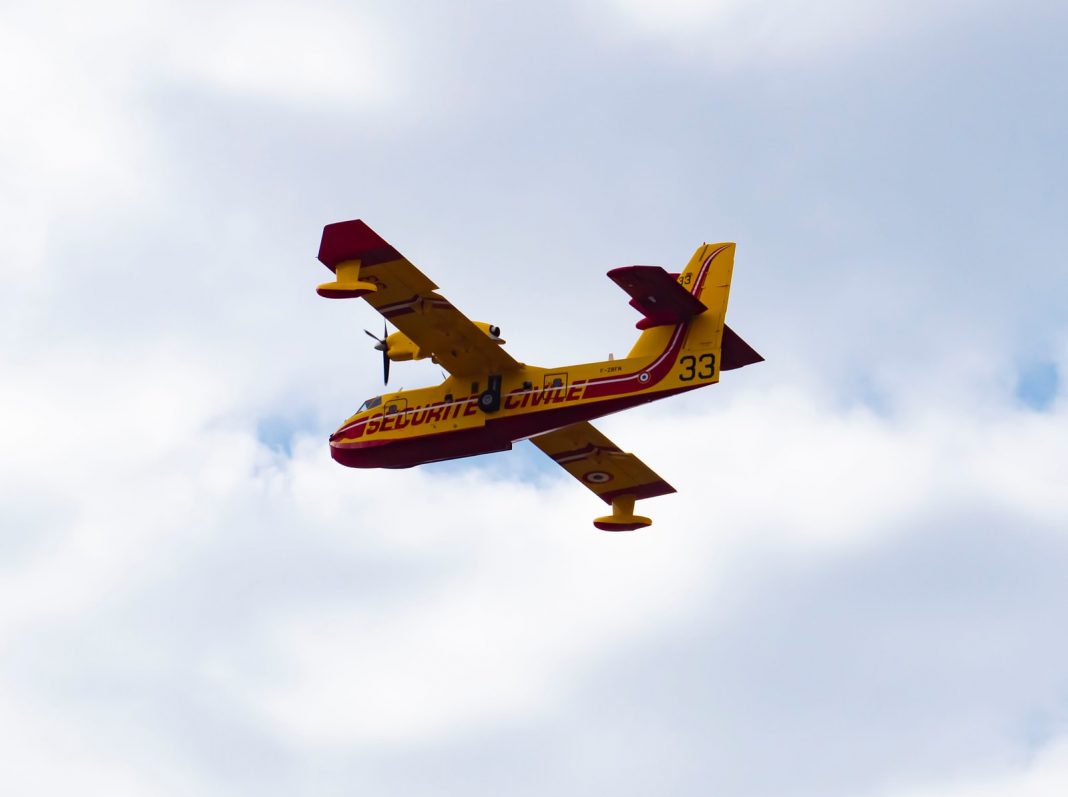 yellow airplane under clouded sky